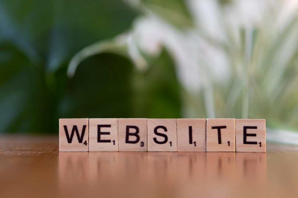 Scrabble tiles on a wooden surface forming the word 'Website', symbolizing digital communication.